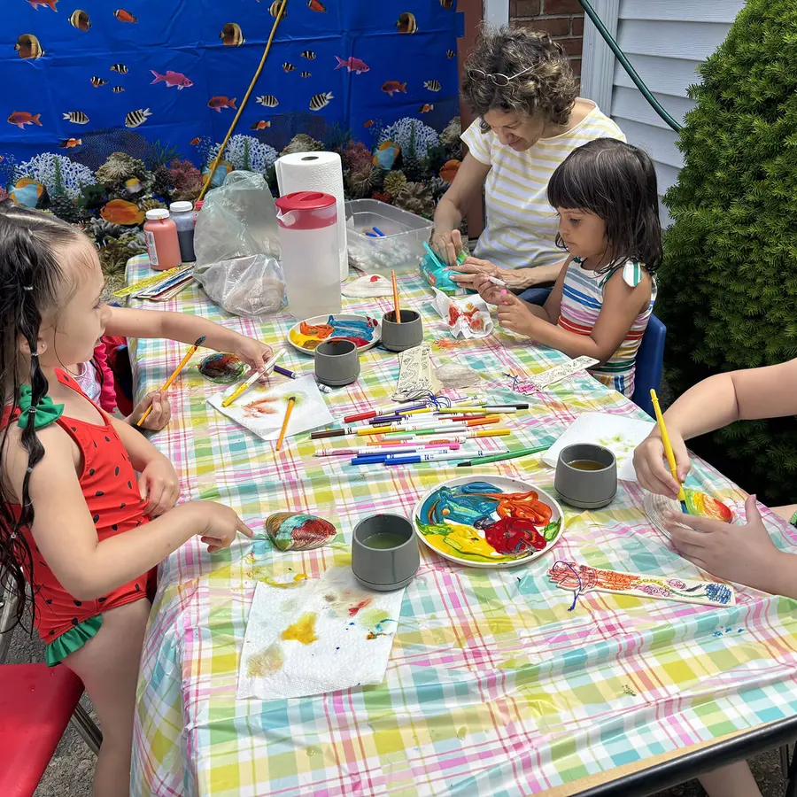 Children painting outdoors during a Calvary Nursery School activity